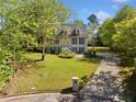 Inviting two-story home with a manicured lawn and a long driveway leading to the property at 3200 Hampton Ridge Way, Snellville, GA 30078
