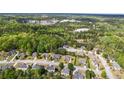 Aerial view of a residential community surrounded by lush green forest and distant quarry at 3601 Cedar Springs Ln, Loganville, GA 30052