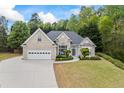 Charming brick home featuring an attached two-car garage, manicured lawn, and lush landscaping at 3601 Cedar Springs Ln, Loganville, GA 30052