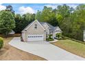 Beautiful brick home with attached garage, long driveway, lush grass and manicured landscaping at 3601 Cedar Springs Ln, Loganville, GA 30052