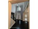 Grand foyer with soaring ceilings, dark hardwood floors, elegant lighting, and a view to the front door at 7030 Bennington Ln, Cumming, GA 30041