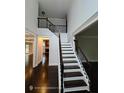 Elegant staircase featuring dark wood steps and wrought iron railings, leading to a brightly lit upper level at 7030 Bennington Ln, Cumming, GA 30041