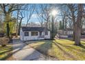 A quaint, single-story house on a sunny lot with mature trees and a concrete driveway at 1870 Oak Valley Rd, Decatur, GA 30035