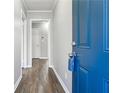 Hallway featuring wood-look floors, neutral walls, and a vibrant blue door creating a welcoming entrance at 1870 Oak Valley Rd, Decatur, GA 30035