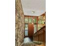 Foyer featuring stone wall, staircase, and stylish pendant lighting at 2208 Guinevere Ne Way, Atlanta, GA 30345