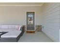 Comfortable front porch seating area with a view of the home's entrance at 81 Creekside Bluff Way, Auburn, GA 30011