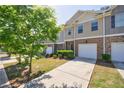 View of a sidewalk leading to townhomes with attached one-car garages and well-maintained landscaping at 8475 Douglass Trl, Jonesboro, GA 30236