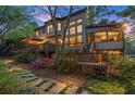 Multi-level deck with outdoor dining, string lights, and lush landscaping at 3749 Watkins Ne Pl, Brookhaven, GA 30319