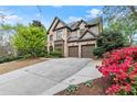 Handsome brick home showcasing a three car garage, manicured landscaping, and a traditional architectural style at 3749 Watkins Ne Pl, Brookhaven, GA 30319