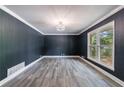 A stylish living room featuring hardwood floors, modern lighting, and dark blue walls at 5287 Chantilly Ter, Atlanta, GA 30349