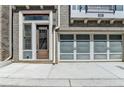 Townhouse featuring a contemporary garage door, brick facade, and convenient front-door entry at 595 Broadview Ne Pl, Atlanta, GA 30324