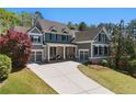 Attractive two-story home with gray siding, brick accents, front porch, manicured lawn, and two-car garage at 68 Highcrest Dr, Acworth, GA 30101