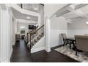 Bright entryway with dark wood floors, staircase, and views into the living and dining room at 3728 In Bloom Way, Auburn, GA 30011