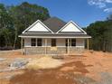 Charming single-story home featuring a brick facade and modern design, set against a lush green backdrop at 95 Rome St, Temple, GA 30179