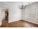 Open dining room featuring hardwood floors, modern chandelier, and a large window at 859 Walking Stick Trl, Auburn, GA 30011