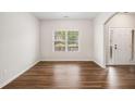 Well-lit living room featuring hardwood floors, and an arched entryway by the front door at 859 Walking Stick Trl, Auburn, GA 30011