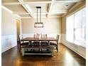 Elegant dining room showcasing coffered ceilings, hardwood floors, and a stylish chandelier over a wooden table at 2671 Moon Chase Ln, Buford, GA 30519