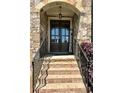 Close-up of the front door with stone facade, steps with iron railings, and a welcoming 'Blessed' sign at 2671 Moon Chase Ln, Buford, GA 30519