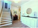 Bright entryway with hardwood floors, a staircase, and decorative white cabinet at 351 Senna St, Marietta, GA 30064