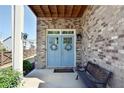Charming brick home entry with a light blue double door adorned with wreaths and a bench at 351 Senna St, Marietta, GA 30064