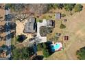 Expansive aerial view showing a house, pool, outbuildings and bordering a long country road at 813 Sandy Creek Rd, Fayetteville, GA 30214