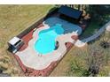 Aerial view of a fenced in-ground pool with diving board, cabana and concrete surround at 813 Sandy Creek Rd, Fayetteville, GA 30214