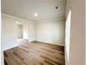 Open living room showcasing hardwood floors, neutral paint, crown molding, and natural light at 5492 Legacy Trl, Douglasville, GA 30135