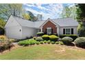 Charming single-story home with manicured landscaping, a brick accent, and an attached two-car garage at 5755 Haterleigh Dr, Alpharetta, GA 30005