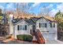 Charming home with a two-car garage, black shutters, wood stairs, and partially fenced front yard at 97 Spring Leaf Dr, Dallas, GA 30157