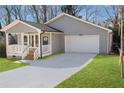 Well-maintained gray home featuring an attached garage and a charming front porch, complemented by a lush green lawn at 2195 Springdale Sw Rd, Atlanta, GA 30315