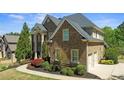 Side view of an elegant brick home with lush landscaping and an attached two-car garage at 5204 Heron Bay Blvd, Locust Grove, GA 30248