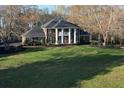 Gorgeous brick home with a grand columned entrance, lush lawn, and mature trees at 5254 Franklin Goldmine Rd, Cumming, GA 30028