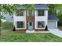 Charming two-story home with a brick facade, light blue door, light gray shutters and a well-maintained front yard at 5728 Norman Ct, Atlanta, GA 30349