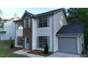 Attractive two-story home with vinyl siding, brick detail, an attached garage, and manicured landscaping at 5728 Norman Ct, Atlanta, GA 30349