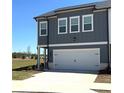 Two-story townhome featuring a two car garage, lawn and modern exterior at 860 Point Place Dr, Loganville, GA 30052