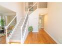 Bright foyer with hardwood floors and an elegant staircase with decorative iron railings at 3819 Meandering Sw Way, Lilburn, GA 30047