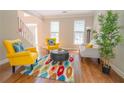 Cozy living room featuring hardwood floors, a colorful rug, and ample natural light at 3819 Meandering Sw Way, Lilburn, GA 30047