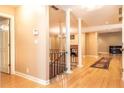 Open-concept living room with hardwood floors, decorative columns, iron railing, and a glimpse of the fireplace at 5325 Pheasant Run, Stone Mountain, GA 30087