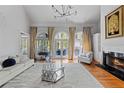 Spacious living room with a fireplace, large windows, and hardwood floors at 105 Grogans Lake Dr, Atlanta, GA 30350