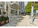 Elegant building entrance with glass doors, covered walkway, and professionally landscaped sidewalk at 1820 Peachtree Nw St # 804, Atlanta, GA 30309