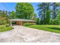 Exterior view of home with long driveway and lush green lawn at 2262 Hurt Sw Rd, Marietta, GA 30008
