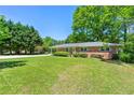 Charming brick home with green lawn, carport and mature trees at 2262 Hurt Sw Rd, Marietta, GA 30008