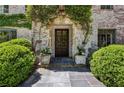 Inviting entryway with stone accents, lush greenery, and a classic wood door at 2648 Rivers Nw Rd, Atlanta, GA 30305