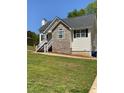 Well-maintained home features a stone accent facade, green lawn, and bright, sunny exposure at 305 Pleasant Forest Dr, Temple, GA 30179
