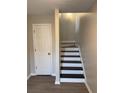 Interior staircase with newly stained steps next to a white door at 1703 Feast Ct, Cumming, GA 30040