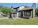 Beautiful two-story home featuring white siding, black trim, shutters, a well-kept lawn, and a driveway at 1703 Laurel Creek Cir, Lithonia, GA 30058