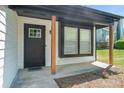 Inviting front porch features a dark-colored door and window with natural wood columns at 1703 Laurel Creek Cir, Lithonia, GA 30058