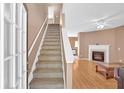 Inviting foyer with carpeted staircase leading upstairs adjacent to a living room featuring fireplace and wood floors at 200 Arrowhead Ln, Canton, GA 30114