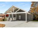 Gray home features a covered porch, carport, and modern front door, with a concrete driveway offering ample parking at 221 Silver Springs Sw Cir, Atlanta, GA 30310