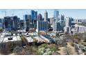 Stunning aerial view of the city skyline with modern buildings surrounded by lush greenery and mature trees at 273 12Th Ne St # 114, Atlanta, GA 30309